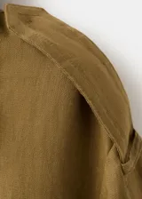 Chaqueta corta de lino color verde militar, con cuello solapa ancho, doble botonadura frontal y bolsillos laterales.