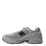 Championes New Balance modelo 509, color gris claro con detalles en gris oscuro y negro. Presentan una combinación de malla transpirable y superposiciones de gamuza. El logo 'N' lateral es negro.