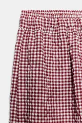 Pantalón bombacho con estampado de cuadros vichy en color rojo y blanco, cintura elástica con cordón de ajuste y puños elásticos en los tobillos.