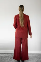 Blazer de lana con estampado de cuadros vichy en tonos rojo y marrón, solapas clásicas, dos bolsillos delanteros y cierre frontal de botones.
