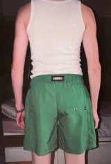 Short de baño verde con estampado de símbolos de yin y yang en blanco y negro. Tiene cintura elástica ajustable con cordón, bolsillos laterales y traseros, y logo bordado.