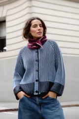 Saco tejido reversible de manga larga y cuello a la base. Presenta un diseño vanizado en dos colores que genera un efecto visual de contraste, con cierre frontal de botones negros.