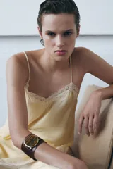 Top lencero de escote en pico y tirantes finos ajustables, confeccionado en tejido fluido con aplicaciones de encaje a tono en el escote y el bajo.