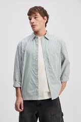 Camisa de manga larga con diseño a rayas verticales en color verde y blanco, cuello clásico y estampa con bordado en la espalda con la frase "Expect Nothing, appreciate everything".