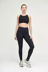 Top deportivo negro con cuello alto y cierre frontal.