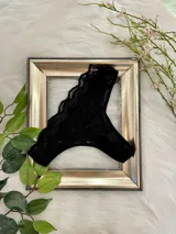 Vedetina de encaje negro con diseño floral, confeccionada en tela suave y elastizada con refuerzo de algodón en la entrepierna.