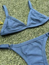 Conjunto de bikini color petróleo, de lycra acanalada, compuesto por un corpiño de triángulo fijo con breteles regulables y una bombacha colaless regulable con argollas metálicas.