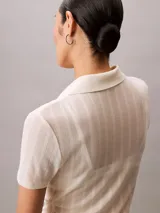 Chomba de manga corta Calvin Klein confeccionada en tejido de punto pointelle texturizado con mezcla de modal elástico. Presenta cuello tipo Johnny abierto y ribetes en punto canalé.