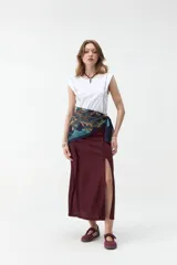 Falda midi de lino color beige, de tiro alto y corte recto, con abertura delantera y cierre cruzado sutil.