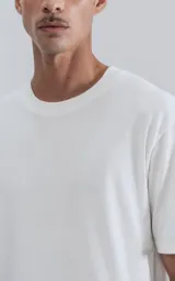 Remera de manga corta y cuello redondo, color blanco, con calce regular y un recorte sutil en la espalda.