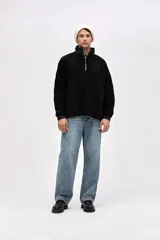 Buzo de sherpa con textura capitoneada, diseño de medio cierre y cuello alto en color beige contrastante. Presenta un calce holgado, mangas largas con puños elásticos y bolsillos laterales.