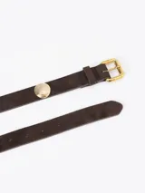 Cinturón de cuero descarne color suela, con hebilla metálica dorada y apliques circulares decorativos distribuidos a lo largo de la pieza.