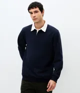 Buzo masculino de algodón con felpa, color beige, con cuello polo blanco contrastante, manga larga y puños acanalados.