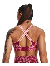 Top deportivo de alto impacto Under Armour, color bordó con estampado gráfico lineal en blanco. Presenta breteles elásticos en color rosado con el logo de la marca, panel de malla en el escote y diseño de espalda cruzada.