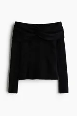Buzo de punto acanalado negro con escote off-the-shoulder y detalle de nudo frontal. Presenta mangas largas y corte ajustado.