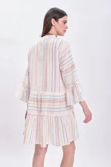 Vestido corto blanco con rayas verticales multicolor, escote en V, mangas largas acampanadas y falda escalonada con volantes.