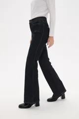 Pantalon de jean azul oscuro con corte flare, tiro alto y bolsillos frontales tipo parche.