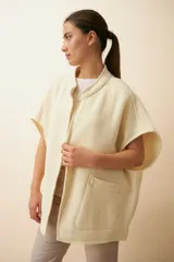 Chaleco marrón de lana con cuello mao, solapas pronunciadas, bolsillos ojal y terminaciones envivadas.