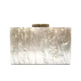 Clutch rectangular rígido con diseño nacarado en tonos plateados y blancos. Cierre dorado en la parte superior y asa de cadena plateada desmontable.