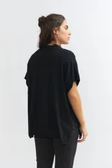 Cardigan negro de tejido de punto, corte amplio y mangas cortas.