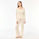 Conjunto de pijama de dos piezas en color blanco con estampado floral pequeño. Incluye una remera de manga larga con botones frontales y un pantalón largo de corte recto, ambos confeccionados en tejido de punto calado.