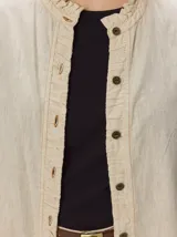 Camisa de denim liviano de lyocell, color azul, de corte relajado, con cuello alto fruncido y cartera de botones con detalles de volados.