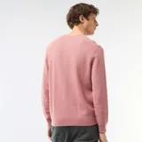 Sweater de punto con textura nido de abeja, color rosado, con cuello redondo y mangas largas.