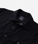 Camisa de manga larga confeccionada en sarga de algodón color verde menta, con cuello inglés y cierre frontal de botones negros. Presenta dos bolsillos de parche con solapa en el pecho y puños con botones.