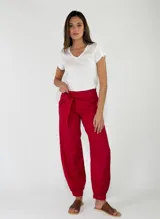Pantalón de lino color rojo, de corte holgado con botamangas elastizadas y diseño cruzado en la cintura con lazo ajustable.