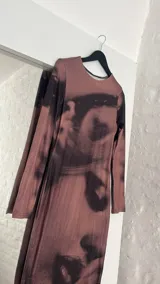 Vestido midi marrón con estampado abstracto en negro, de corte ajustado y manga larga.