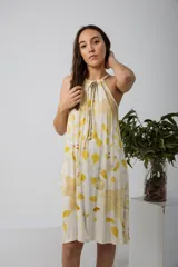 Vestido midi con estampado de hojas amarillas y marrones, corte suelto y cuello halter con lazo.