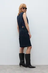 Bermuda de jean en color azul oscuro, con corte recto y largo hasta la rodilla. Presenta costuras a la vista en tono contrastante, cierre frontal con botón y bolsillos laterales.