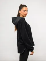 Buzo de polar negro con capucha, cierre frontal parcial y bolsillos laterales. Presenta detalles en nylon a tono en la capucha, la solapa del cierre y los bordes de los bolsillos, con el logo de la marca bordado en el pecho.