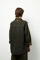 Sobrecamisa negra de algodón, de manga larga y corte unisex, con botones veteados.