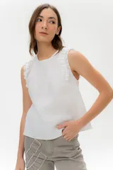 Musculosa negra de lino con cuello redondo y volados en los hombros.