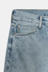 Jeans de tiro bajo y corte recto, con diseño de cinco bolsillos, trabillas en la cintura y efecto lavado con detalles de rotos en el frente.