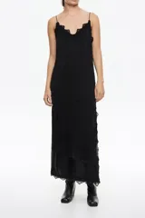 Vestido midi negro de silueta línea A, confeccionado en viscosa, con escote en V profundo y tirantes finos. Presenta detalles de encaje en el escote y en el bajo, con una abertura lateral adornada con encaje.
