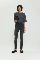 Pantalón skinny negro de tiro medio, confeccionado en denim premium con logo bordado en el bolsillo trasero.