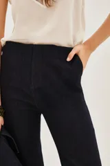 Pantalon de corte recto y tiro alto, confeccionado en denim oscuro con acabado liso.