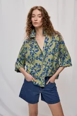 Camisa de viscosa fluida en color verde militar con estampado floral en azul, corte amplio, cuello camisero, escote en V y mangas largas con puños elastizados.