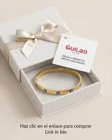 Esclava rígida de acero con baño de oro, decorada con cinco dijes de ojo turco incrustados. Se presenta junto a una pulsera de cadena fina con un dije de mano de Fátima.