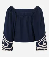 Blusa corta de algodón color azul marino, con escote cuadrado, mangas largas abullonadas y detalle de bordado en cuerda blanca en los puños.