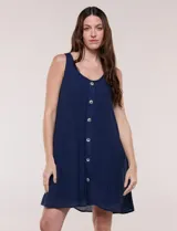 Vestido corto blanco de calce suelto y estilo relajado, de la marca Zac & Rachel. Cuenta con breteles anchos, escote redondo, abotonadura frontal con botones tipo carey, bolsillos laterales y forro a tono.