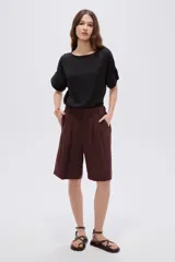 Short ancho de poliéster color negro, de tiro alto y diseño sastrero con pinzas en el frente.