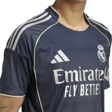 Camiseta de fútbol Adidas del Real Madrid, modelo visitante temporada 25/26. Diseño en tonos azulados con patrón muaré y detalles plateados.