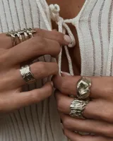 Anillo plateado con textura irregular y diseño rústico.