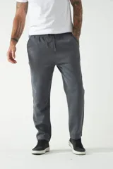 Pantalón de felpa gris para hombre con logo estampado, cintura ajustable y bolsillos.