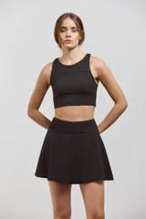 Pollera deportiva corta con calza incorporada, diseñada para actividades como pádel o tenis. Cuenta con cintura ancha de ajuste cómodo y bolsillo invertido en la calza para guardar pelotas. Confeccionada en tejido liviano y elastizado.