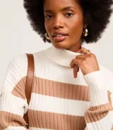 Suéter de punto pesado con cuello alto y mangas largas. Diseño a rayas horizontales en blanco y negro con textura acanalada.