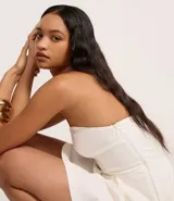 Vestido corto strapless color verde esmeralda, con escote corazón y falda acampanada con pliegues.